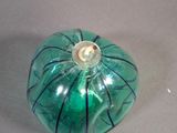 a green glass pumpkin sitting on a table