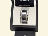 a box with a watch inside of it on a white surface
