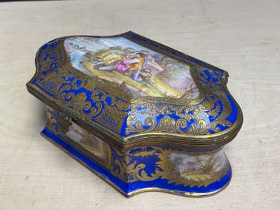 une boîte bleue et dorée sur laquelle figure l'image d'une femme
