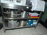 pots and pans on a metal shelf in a kitchen
