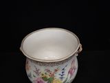 a white bowl with flowers on it sitting on a black surface