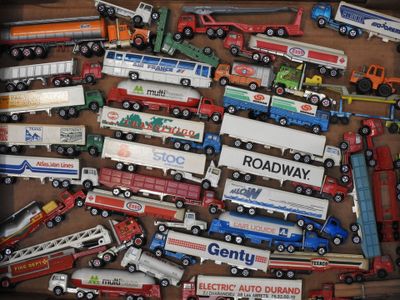 de nombreux modèles différents de camions miniatures exposés dans une boîte
