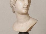 marble bust of a woman with curly hair on a marble base