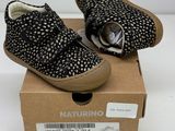 pair of black and white baby shoes in a box on a white surface