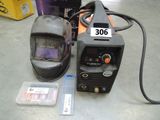 a welding machine and a helmet sitting on a table