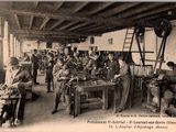 une photo en noir et blanc montrant un groupe de personnes travaillant dans une usine