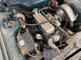 a dirty engine of a car that is sitting in the dirt