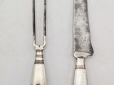 two knives and a knife holder on a white surface