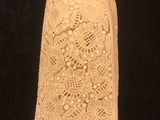 a close up of a piece of white lace on a black surface