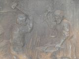 a statue of a man and a woman working on a piece of metal