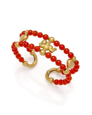 un gros plan sur un bracelet en perles rouges rehaussé de touches dorées