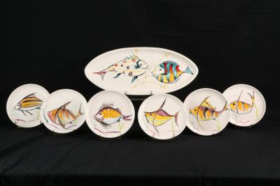 cinq assiettes ornées de poissons peints, posées sur une table noire