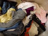 a pile of clothes that is sitting on a bed