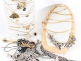 plusieurs colliers et un miroir posés sur une surface blanche, sur fond blanc