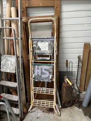 a ladder leaning against a wall next to a pile of wood