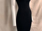 Le mannequin porte une robe noire à col roulé.