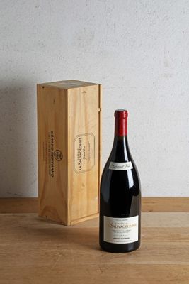 a bottle of wine next to a wooden box on a table