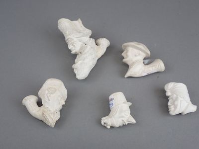 six petites figurines blanches représentant des personnes et des animaux, posées sur une surface grise
