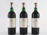 three bottles of red wine sit side by side on a white surface
