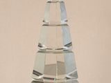 un objet en verre transparent en forme de pyramide posé sur une table
