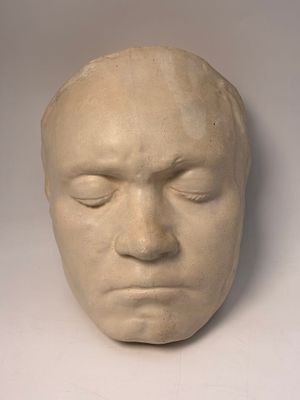 a sculpture of a man ' s face on a white surface