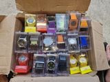a box full of assorted watches sitting on the ground