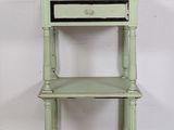 an old green shelf with a drawer on top of it