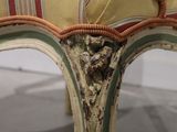a chair with a striped seat on display in a museum