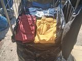 a cart full of clothes sitting on the side of the street