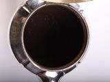a close up of a silver vase on a table