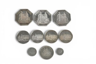 Plusieurs pièces différentes sont disposées en rangée sur une surface blanche