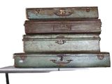 four suitcases stacked on top of each other on a table