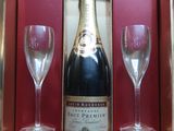 a bottle of champagne and two wine glasses in a box