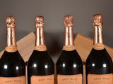 three bottles of champagne sitting on top of a table next to a wooden box