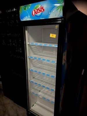 une photo d'un réfrigérateur vide dans une pièce sombre