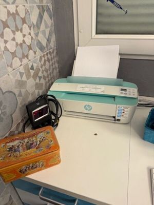 une imprimante posée sur un bureau près d'une fenêtre