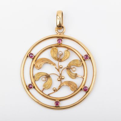 a gold and ruby pendant with a circular design