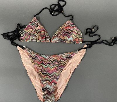 an image of a woman ' s bikini top and panties on a gray surface