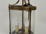 an antique brass lantern with two lamps inside of it on a white background