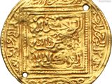 a close up of a gold coin with arabic writing on it