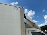 a white truck with a white roof and a blue sky in the background