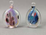 two glass perfume bottles with different designs on them