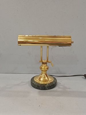 a gold desk lamp that is on top of a marble base