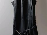 a black dress hanging on a hanger on a wall