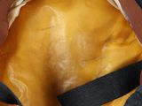 a close up of a brown bag with a black strap