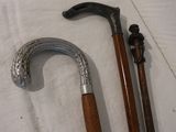 two old walking canes and a walking stick on a table