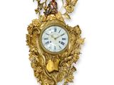 une horloge en or sur le mur avec un oiseau dessus