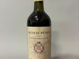 une vieille bouteille de vin posée sur une table blanche