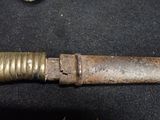 a very old knife that is laying on a table