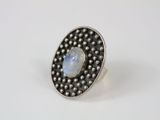 a silver ring with a rainbow stone surrounded by beads